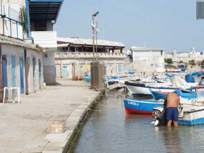 ...per andare poi a incamminarsi verso sinistra sulla banchina che ospita i rispostigli dei pescatori